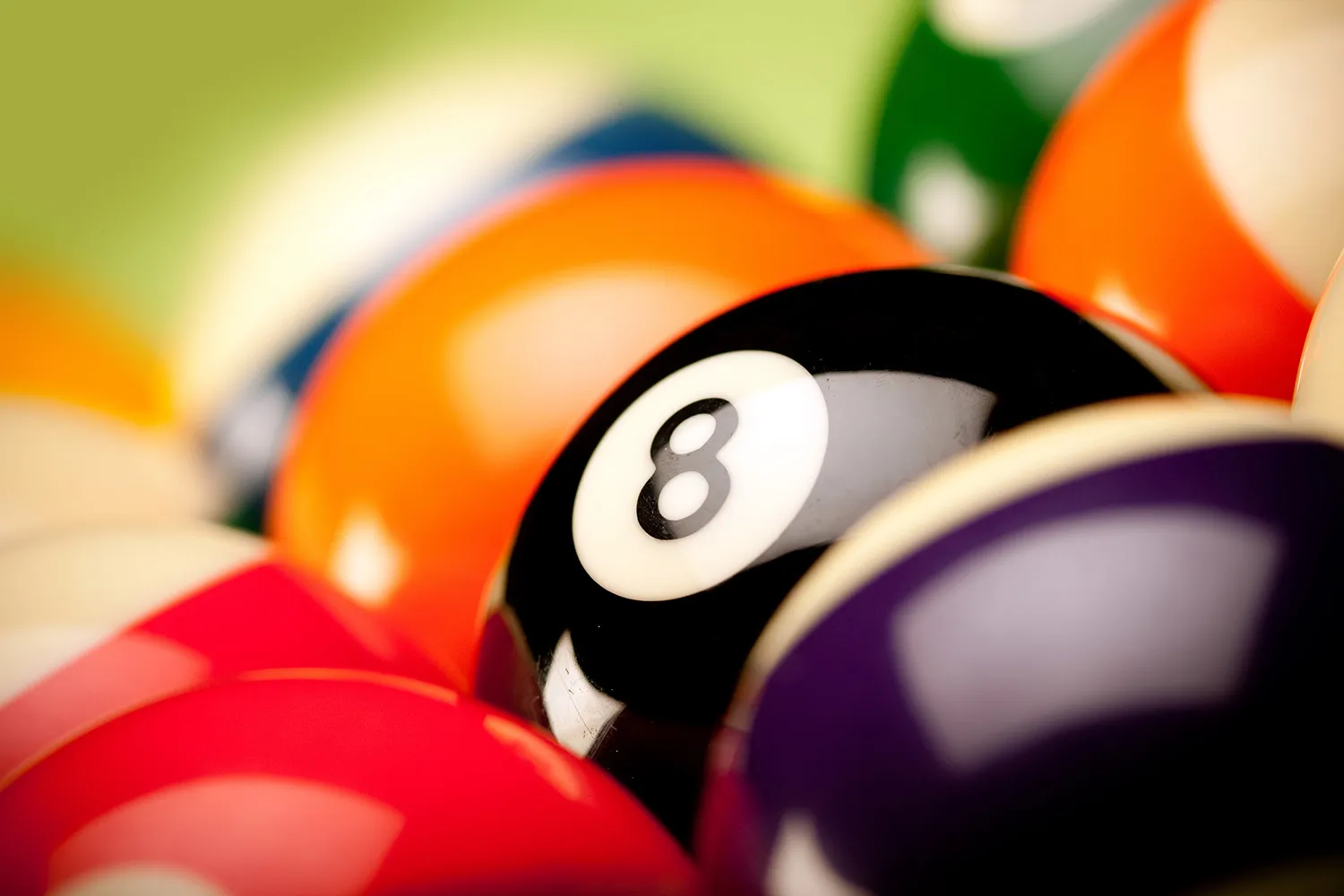 Pool balls including the 8 ball on a pool table surface